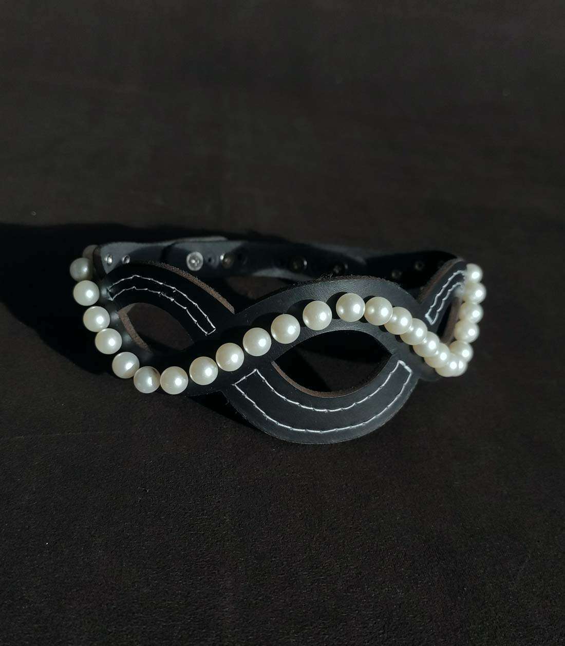 schwarzes Lederhalsband im Wellendesign mit Kunstperlen-Nieten und Steckverschluss über Stopper