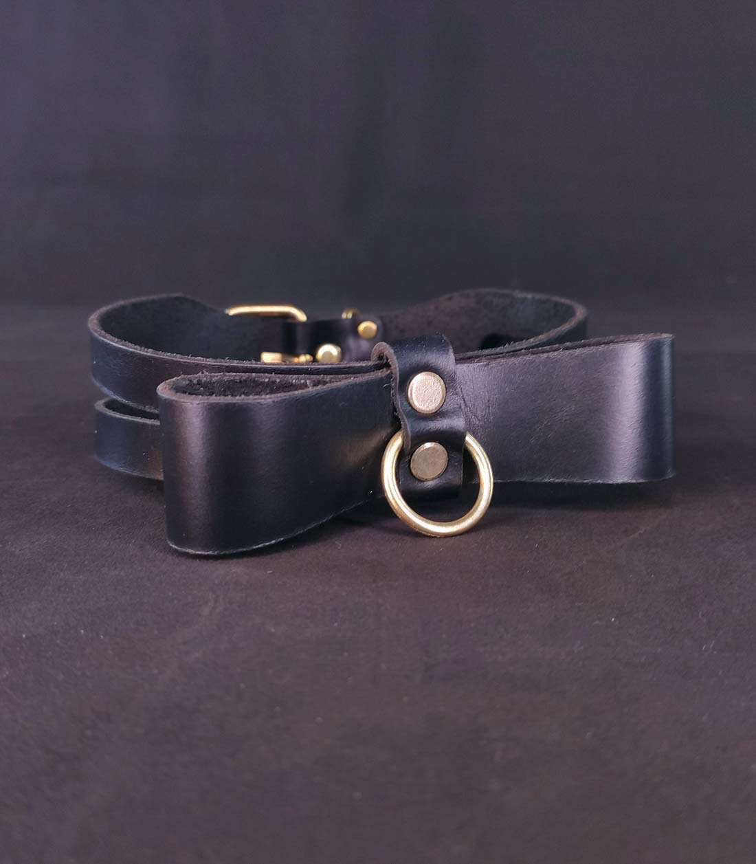 schwarzes Halsband mit Cutouts, Lederschleife, einem abnehmbaren O-Ring und einer Dornschließe auf der Rückseite