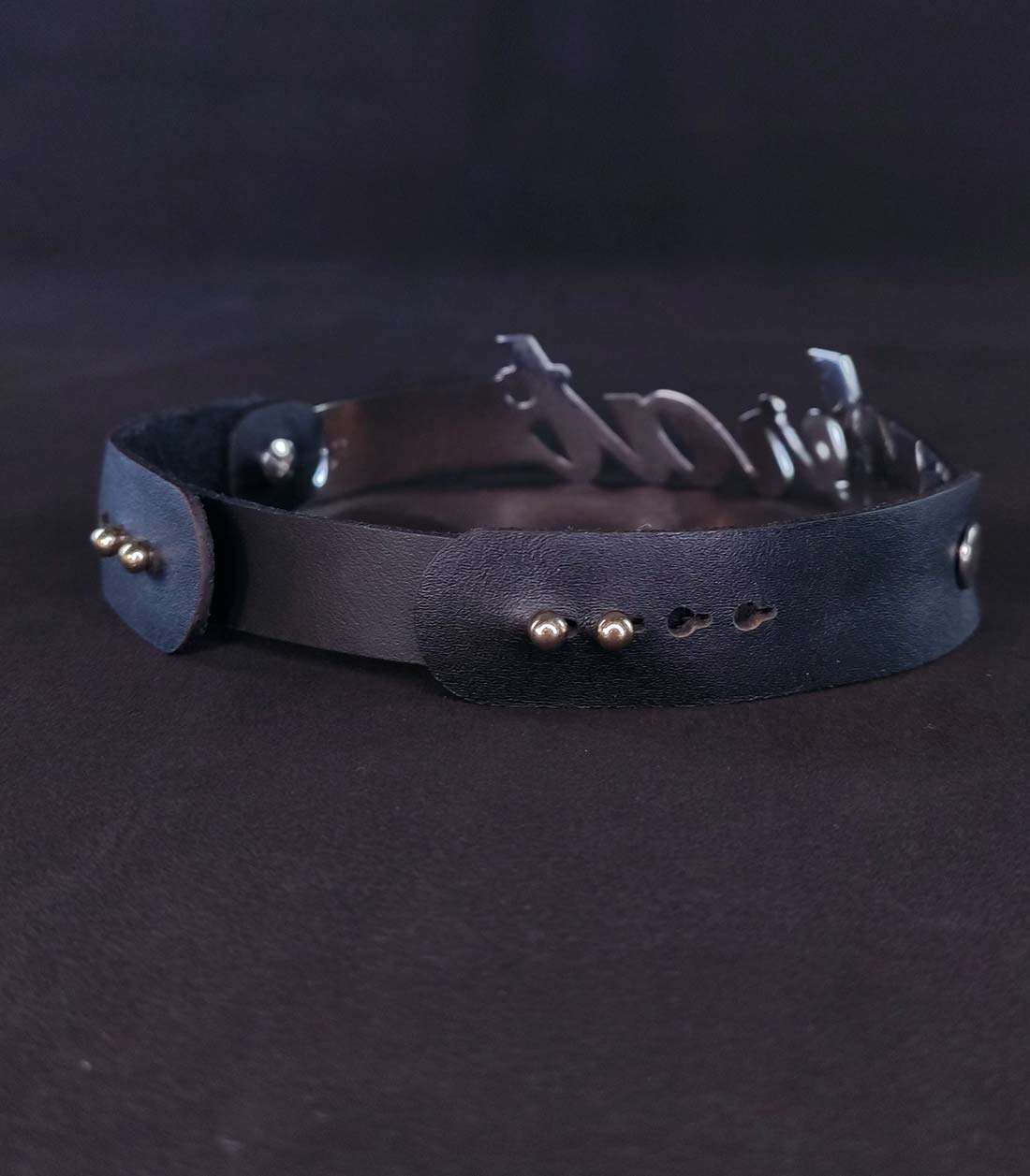 schwarzes Lederhalsband mit einem Edelstahlbügel mit "brat" Schriftzug und einem Steckverschluss über Stopper