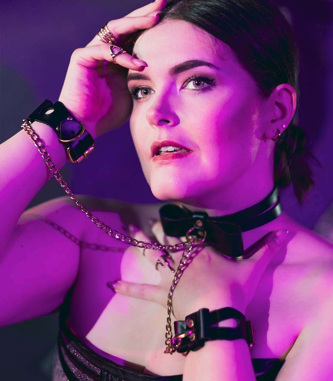 Ketten mit Karabinern, die schwarze Bow Cuffs über ein Collar mit O-Ring miteinander verbinden