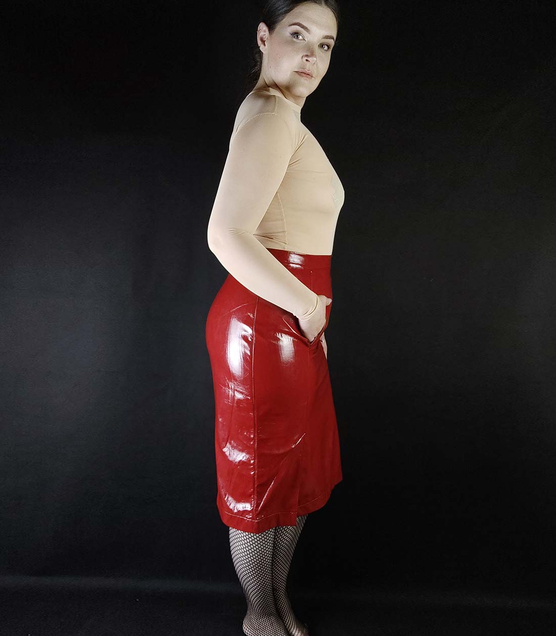 Seitenansicht vom Outfit aus hautfarbigem Body mit Ropebunny Bestickung und rotem Gloss Rock