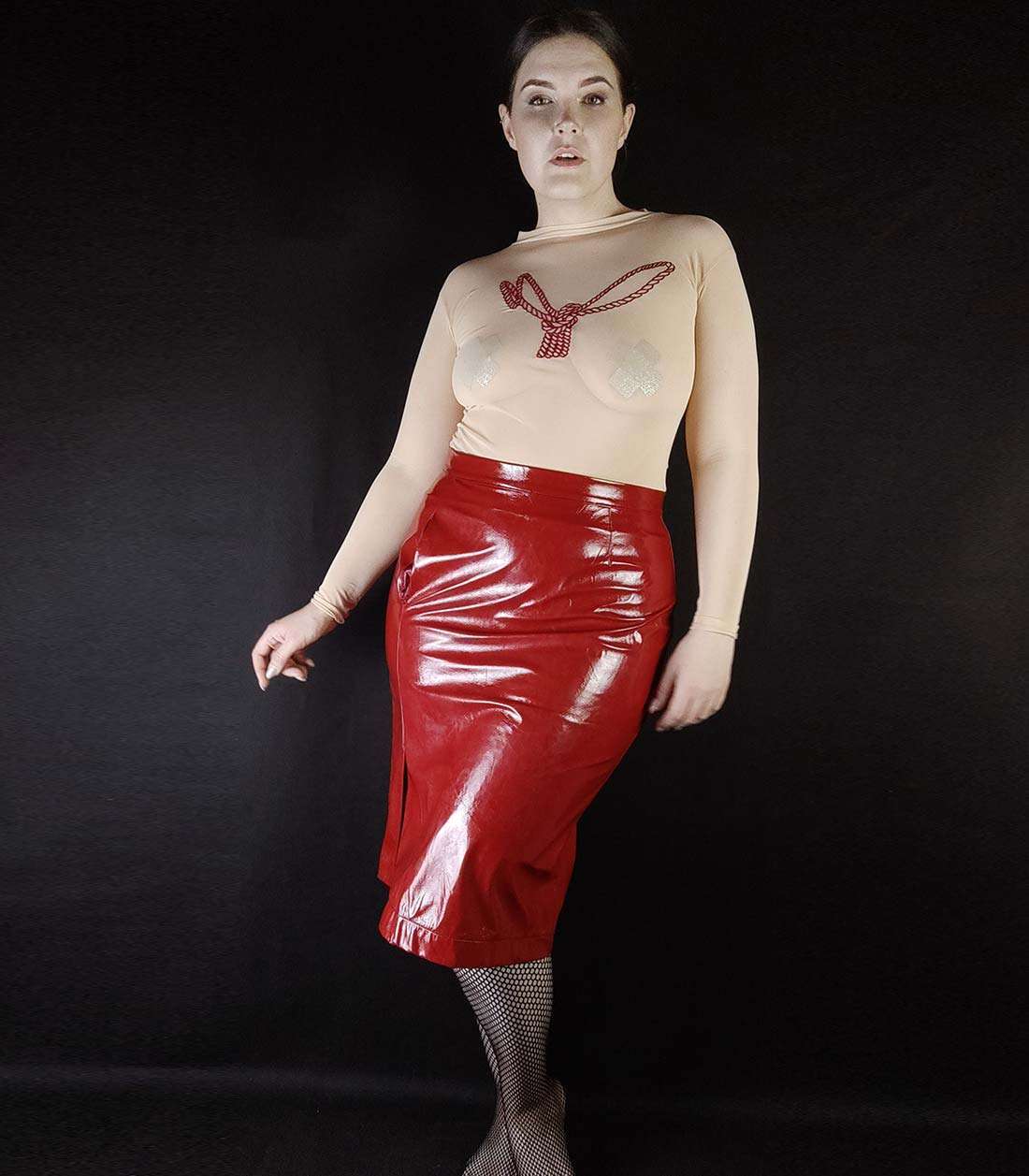 Outfit aus hautfarbigem Body mit Ropebunny Bestickung und rotem Gloss Rock