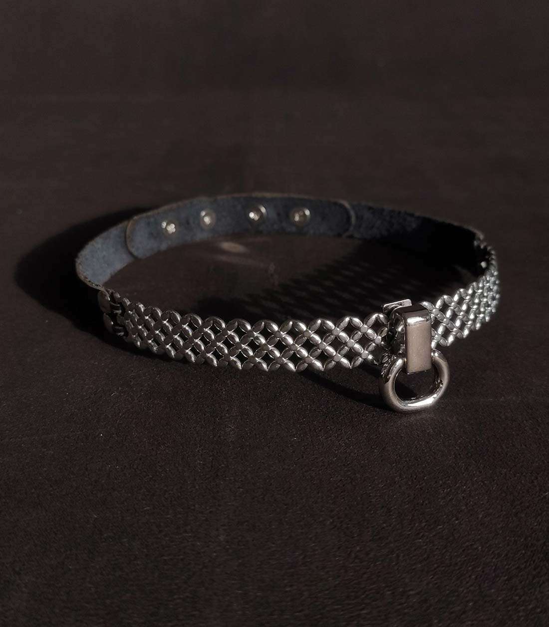 Lederhalsband mit Edelstahlbügel mit überkreuzten Details und kleinem O-Ring, der über einen Steckverschluss mit Stoppern verschließbar ist