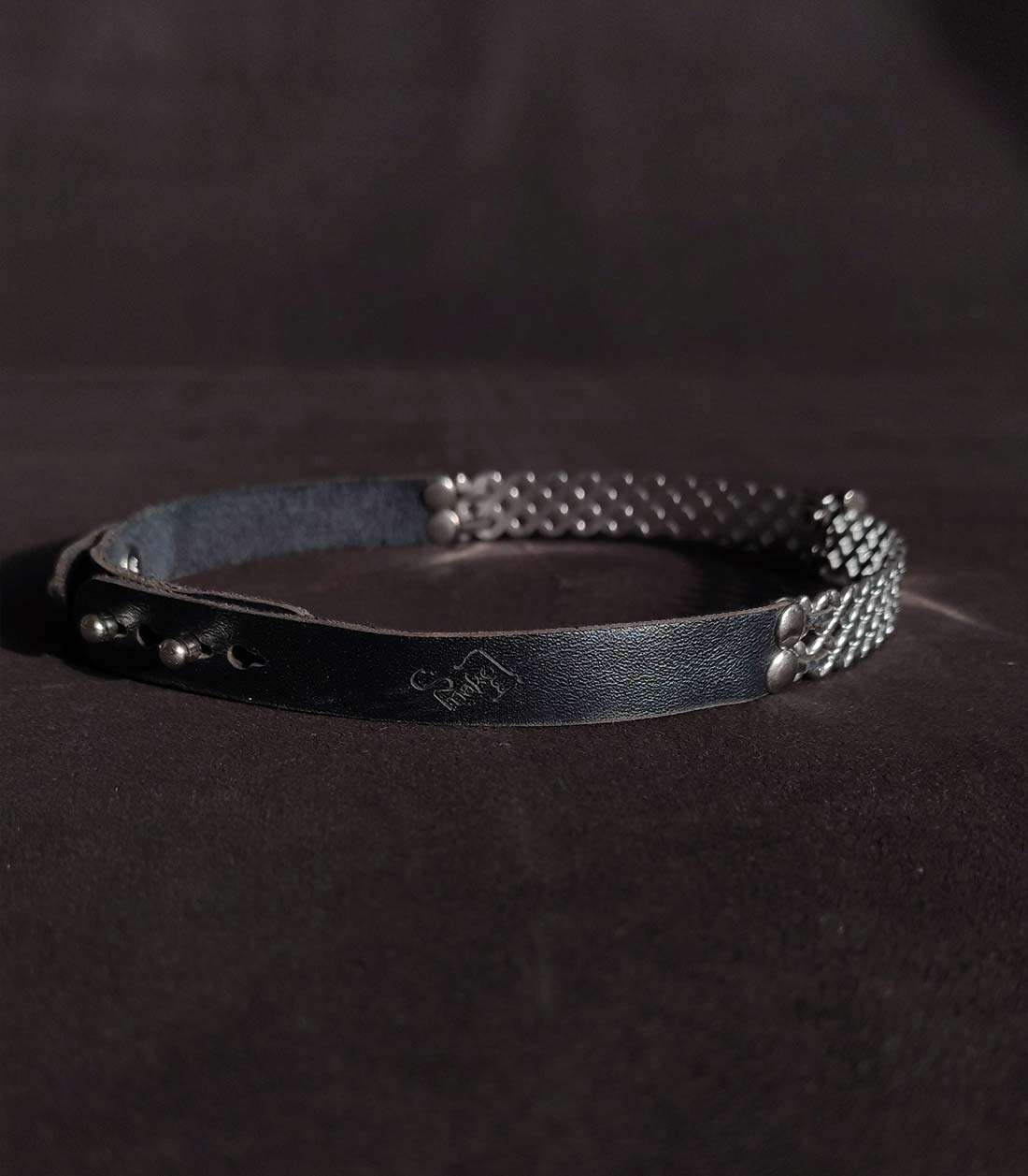 Lederhalsband mit Edelstahlbügel mit überkreuzten Details und kleinem O-Ring, der über einen Steckverschluss mit Stoppern verschließbar ist