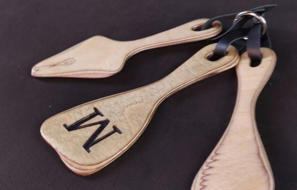 drei Mini Paddles als Set in verschiedenen Formen aus Birkenschichtholz, bei denen ein Paddle ein eingraviertes "M" hat