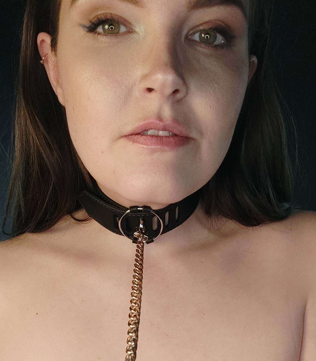 schwarzes Lederhalsband mit silbernem O-Ring und Steckverschluss über Stopper, der mit einer Kette verbunden ist