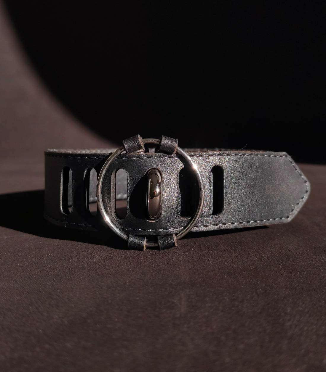 schwarzes Lederhalsband mit silbernem O-Ring und Steckverschluss über Stopper