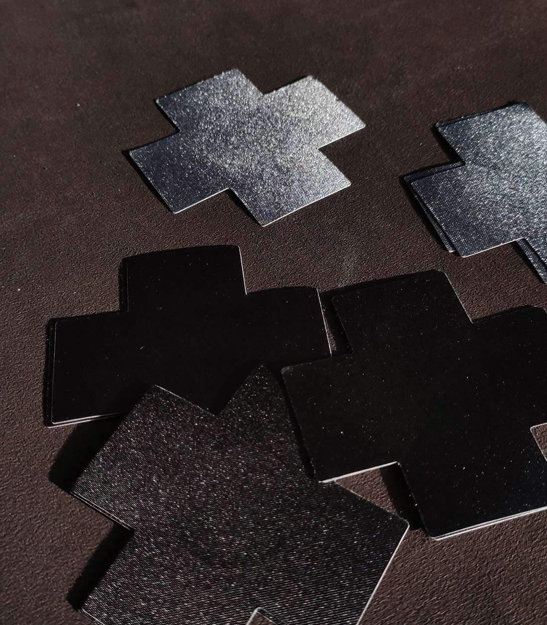 kreuzförmige Nipple Patches mit schwarzer Stoffoberfläche