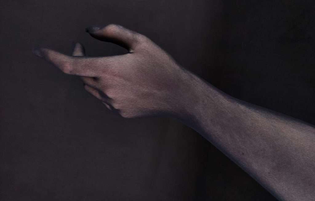 Hand mit schwarzem Feinstrumpf-Handschuh
