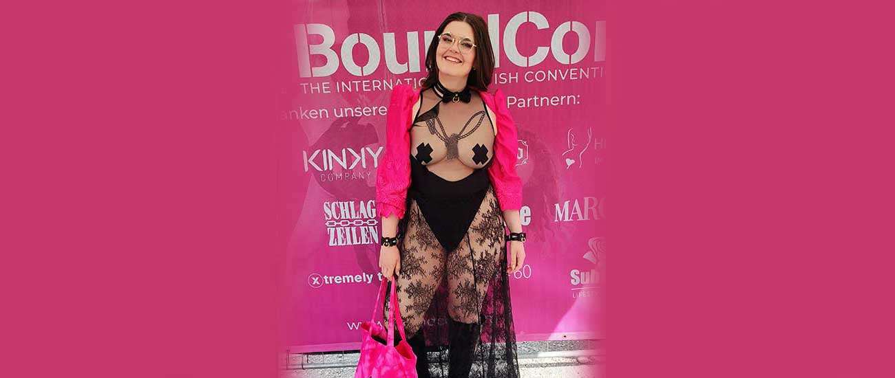 Gründerin von Make Me steht lächelnd vor einem großen BoundCon Plakat